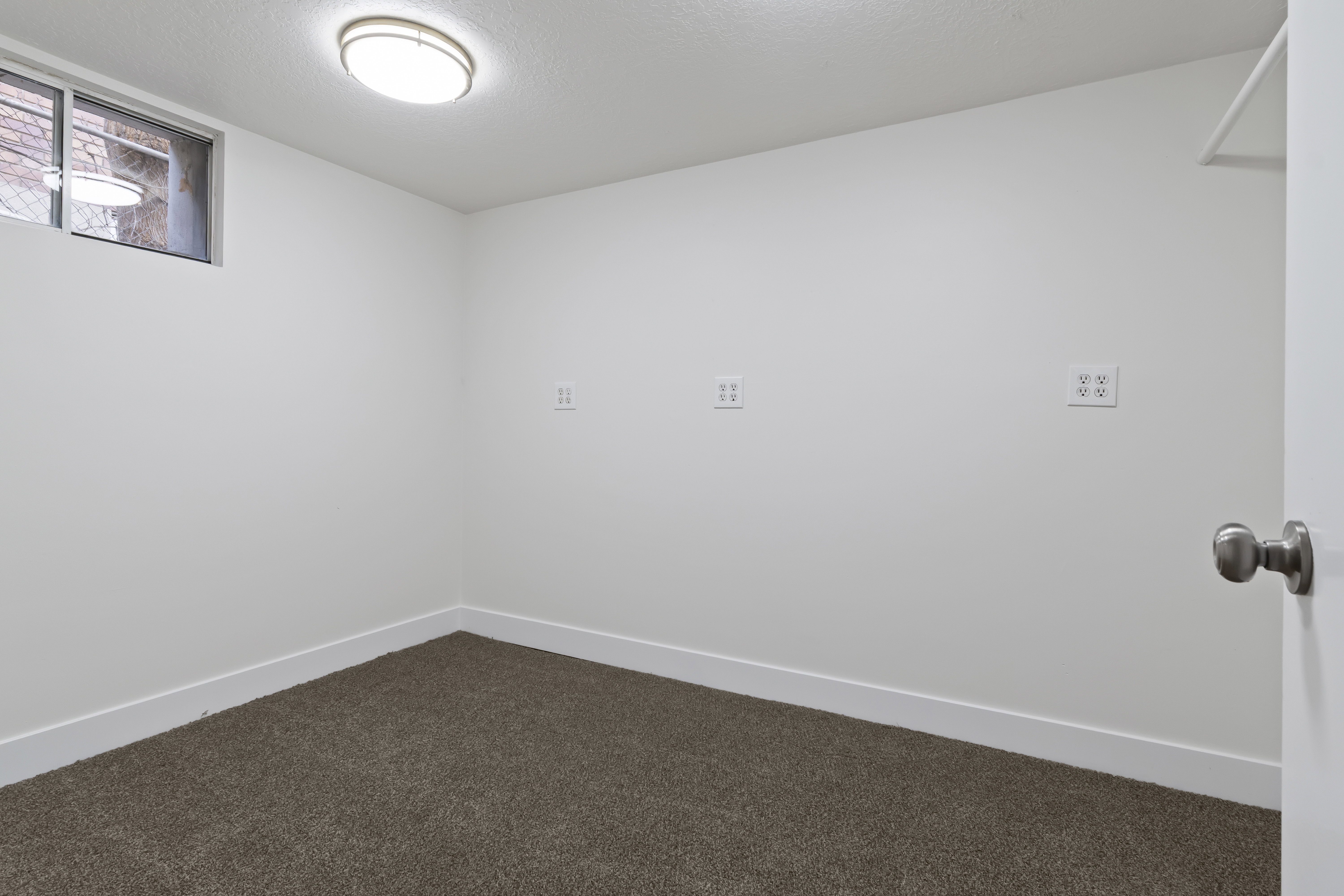 Room with neutral carpet flooring, white painted walls, and a recessed window