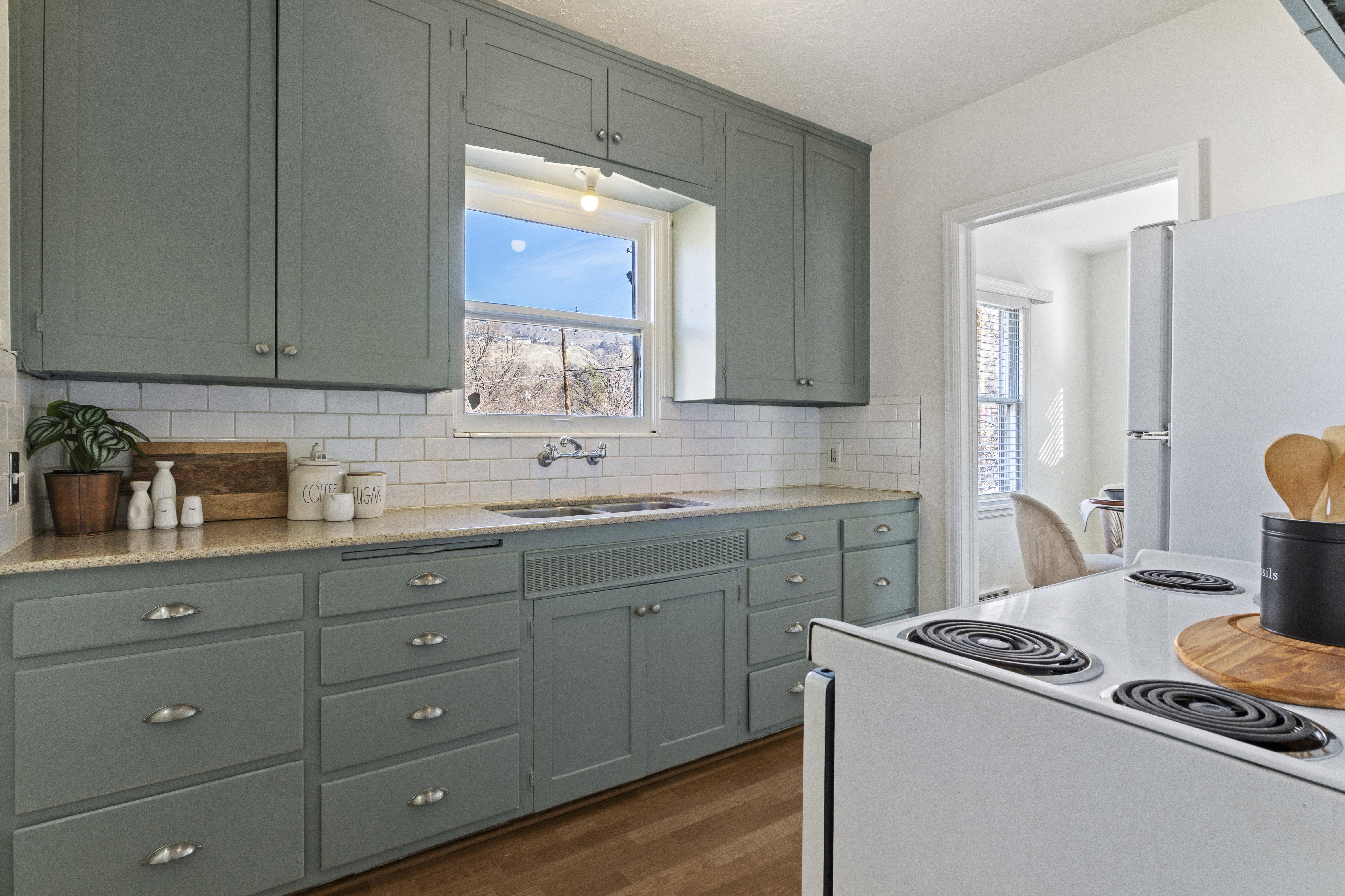Kitchen featuring ample cabinetry, subway tile backsplash, and a double-basin sink