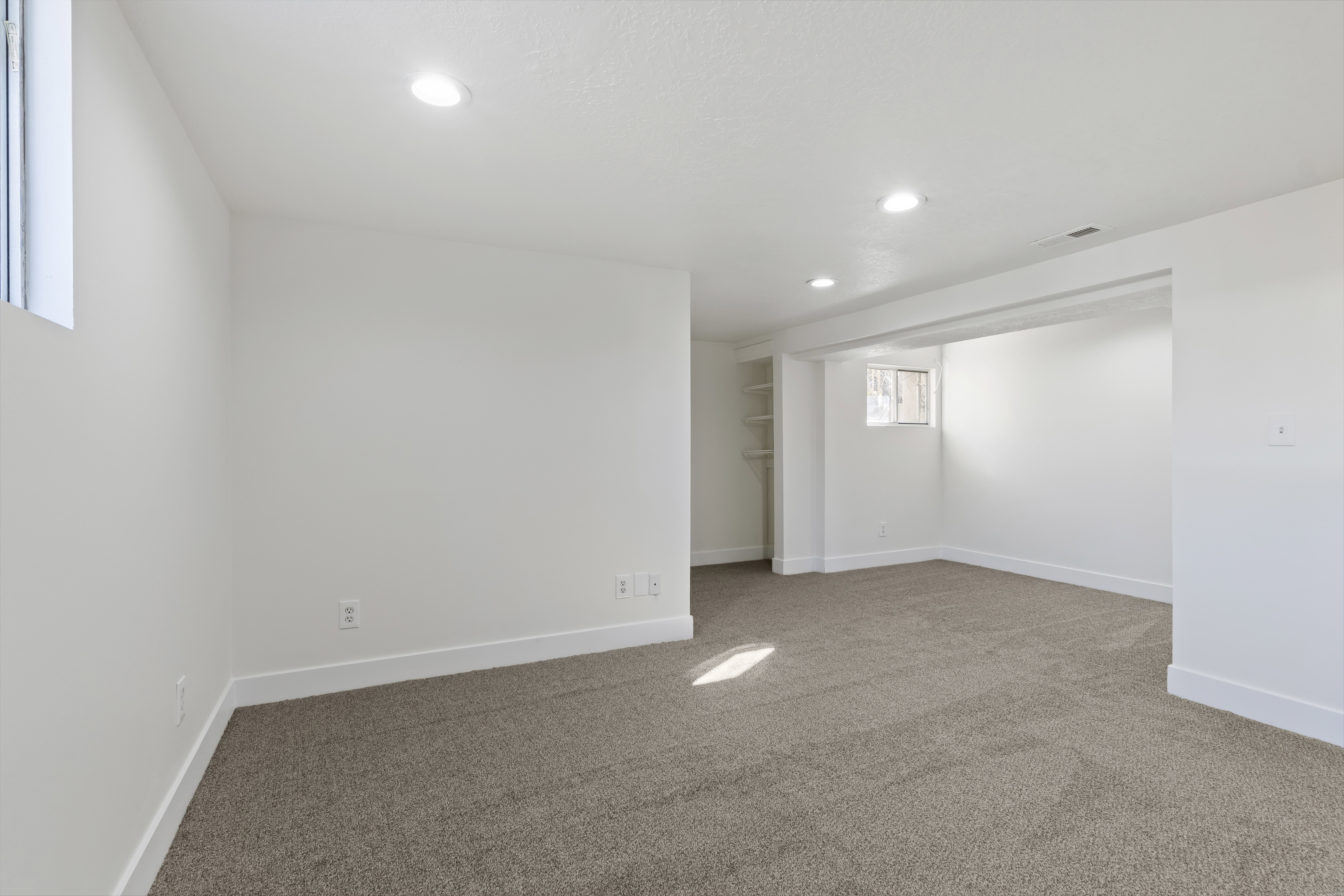 Spacious interior featuring neutral carpeting, recessed ceiling lighting, and crisp white walls