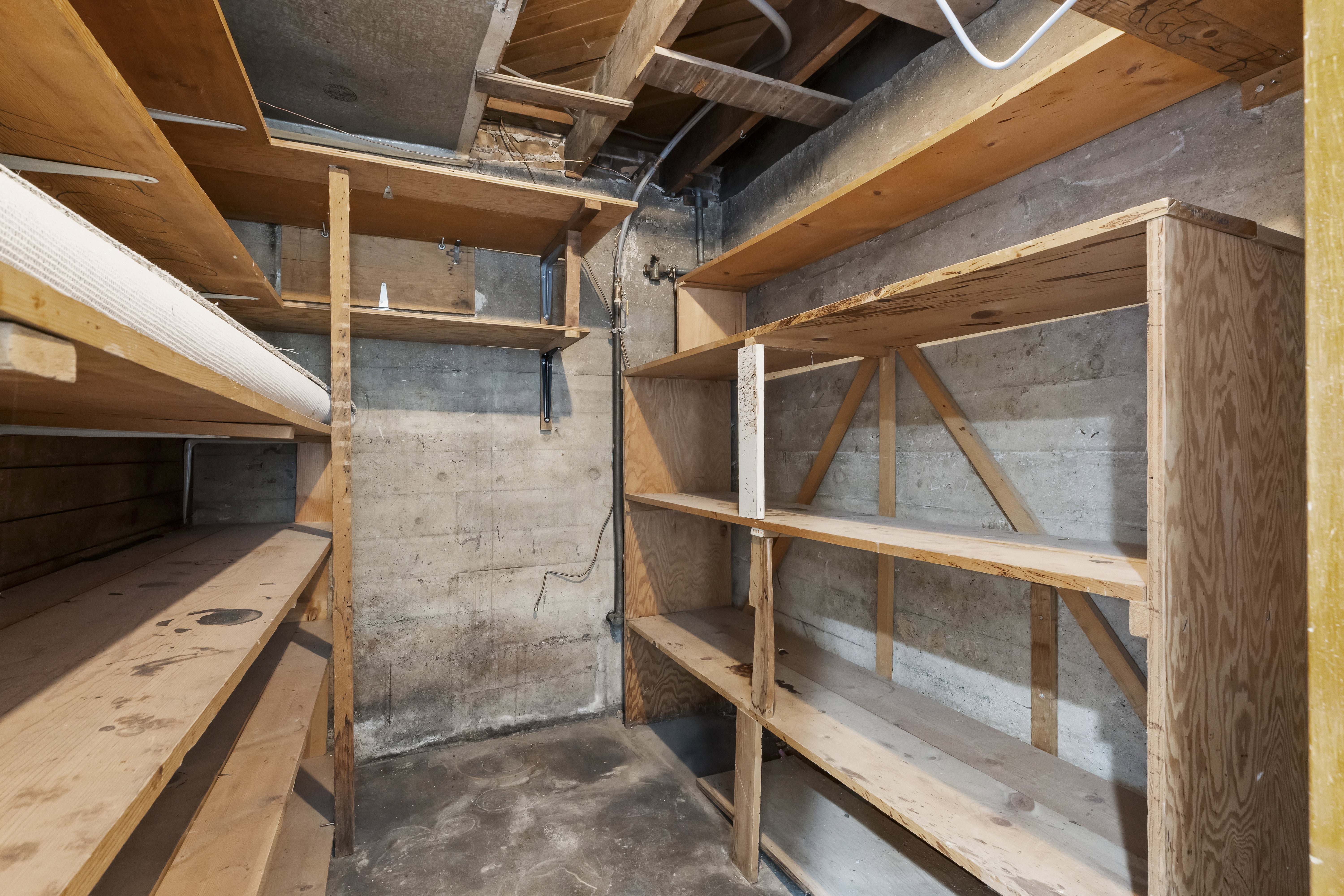Unfinished basement area featuring exposed concrete walls and ceiling
