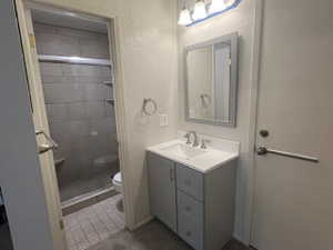 Primary Bathroom featuring a gray vanity with an integrated sink, brushed nickel faucet, and walk-in shower.