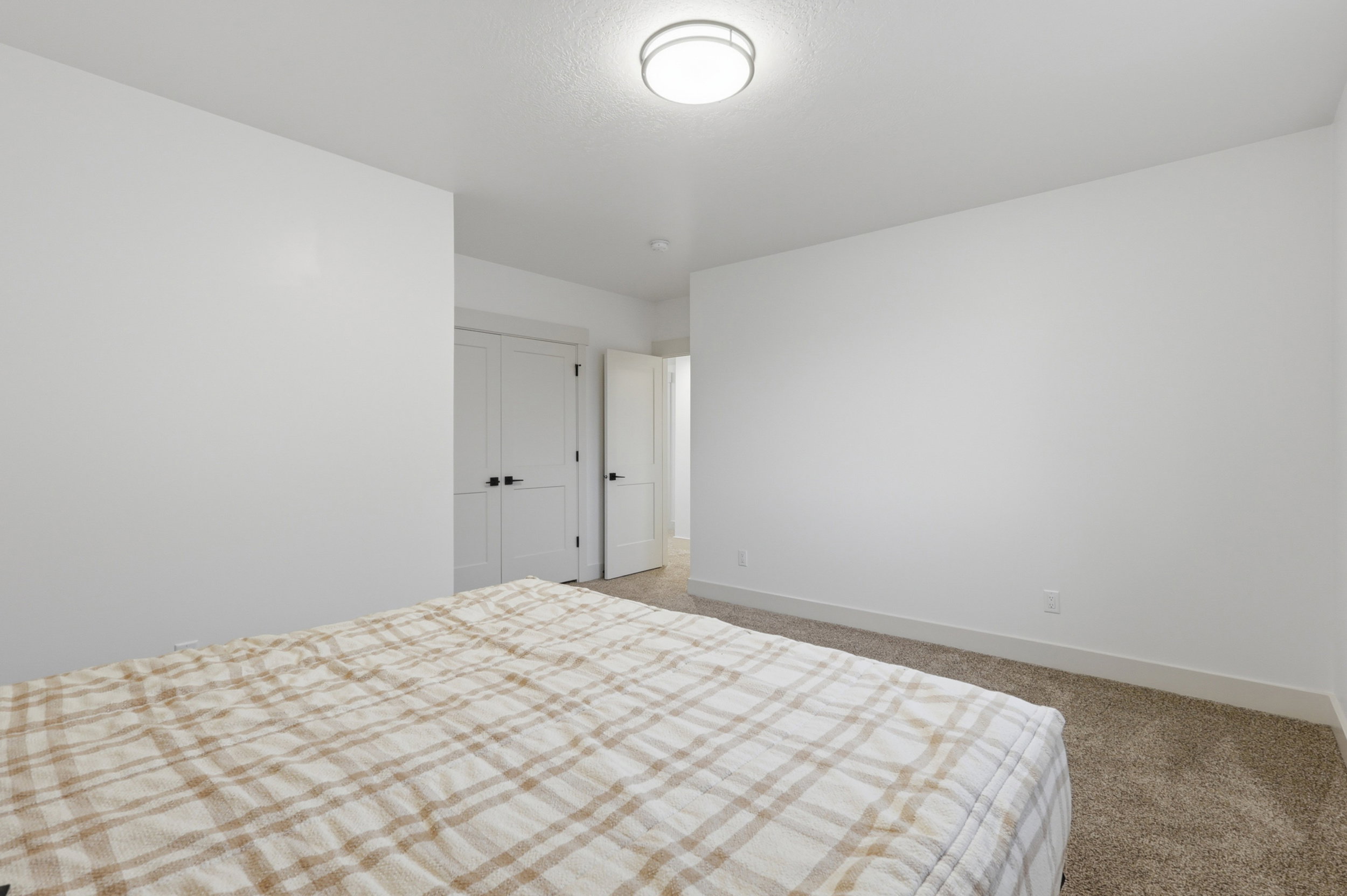 Bedroom #5 Carpeted room featuring white walls, a flush-mount ceiling light, and white interior doors with matte black hardware