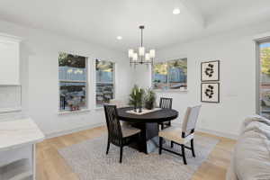 Dining area featuring light wood-finish flooring and a contemporary chandelier