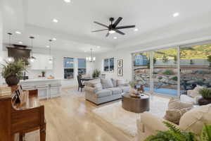 Open-concept living area featuring light wood-finish flooring, recessed lighting, and a modern ceiling fan