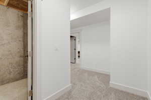 Hallway featuring light-toned carpet flooring, white walls, white trim, and recessed lighting