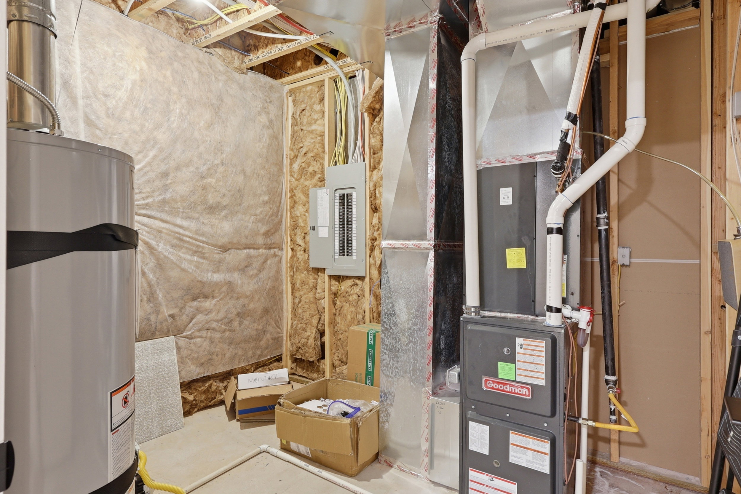 Mechanical room featuring an everscent diffusion system, water heater, insta-hotwater, furnace, electrical panel, Soft water system, and exposed ductwork