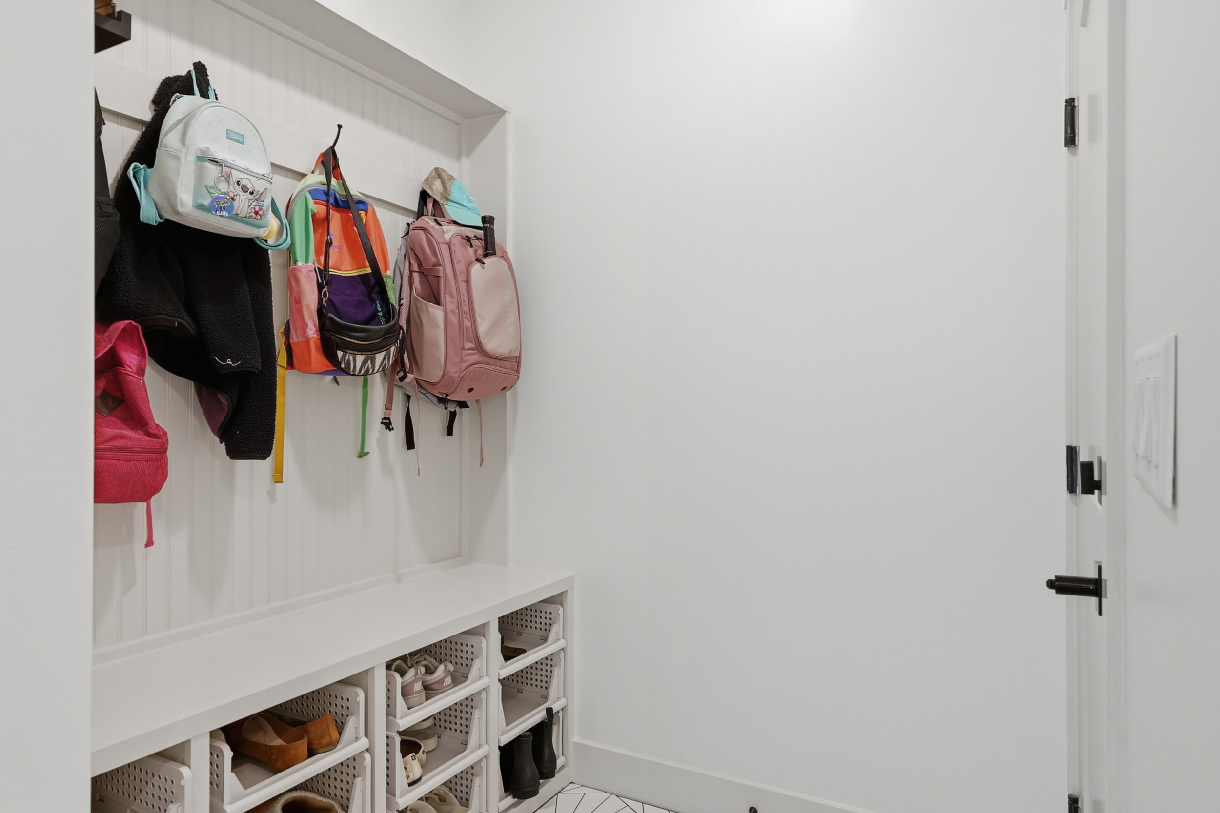 Built-in mudroom bench with beadboard backing, integrated storage cubbies, and overhead hooks