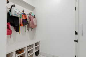 Built-in mudroom bench with beadboard backing, integrated storage cubbies, and overhead hooks