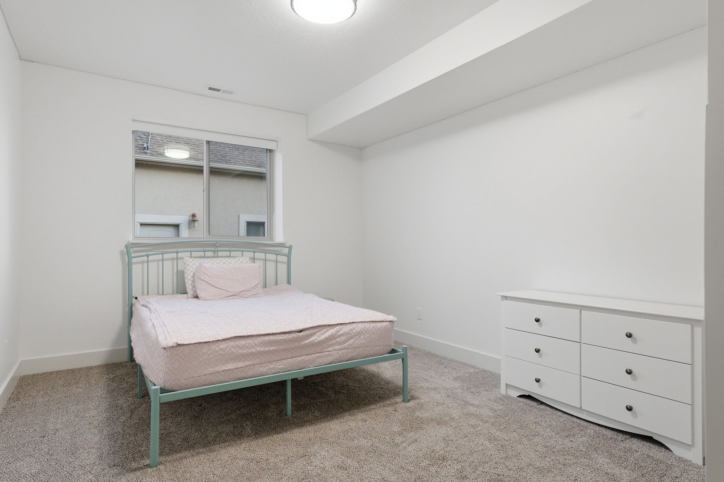 #6 Carpeted room with a ceiling light fixture, white walls, and a single window