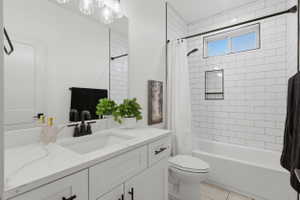 Modern bathroom featuring a single vanity with a white countertop and undermount sink, black-finish faucet, and a large mirror