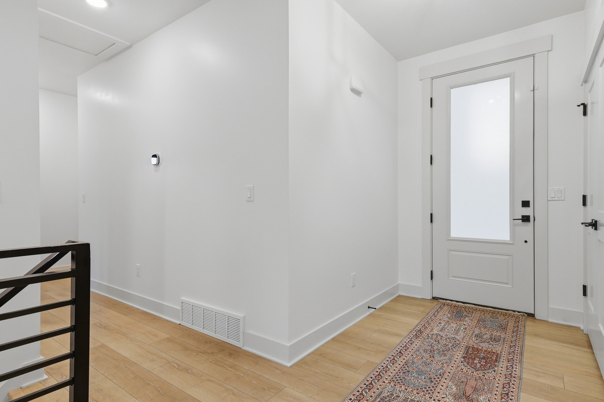 Entryway featuring a white door with frosted glass panel and black hardware