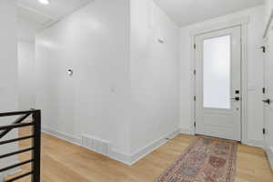 Entryway featuring a white door with frosted glass panel and black hardware