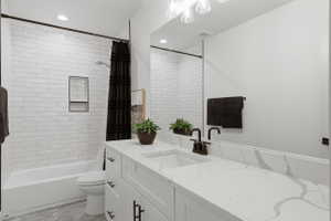 Bathroom featuring a white subway tile shower surround with a built-in niche, a white tub, and a vanity with a white countertop