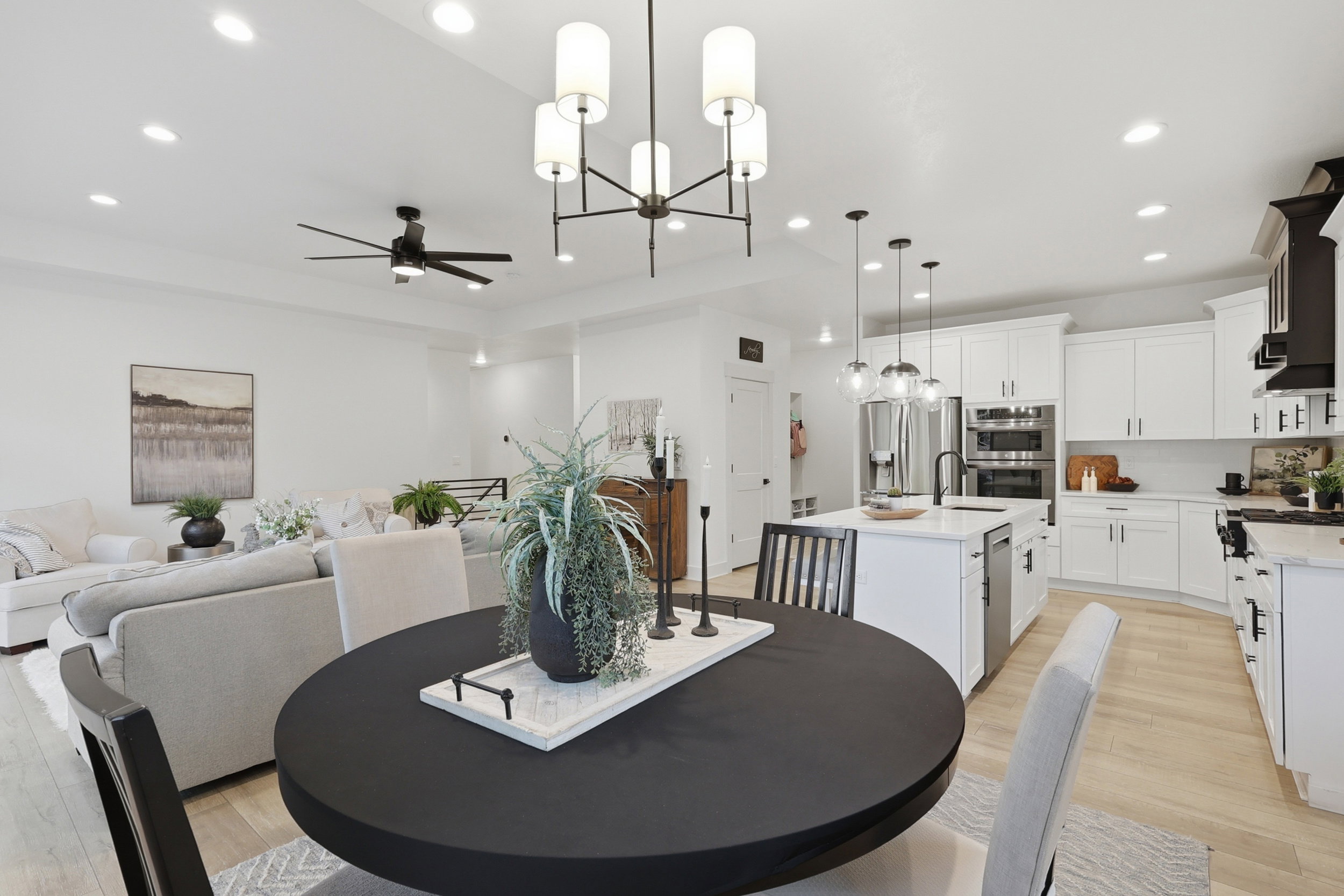 Open-concept living space featuring light wood-finish flooring, recessed lighting, and a contemporary chandelier