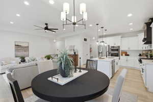 Open-concept living space featuring light wood-finish flooring, recessed lighting, and a contemporary chandelier