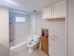 White tiled shower surround with a built-in tub, a window, and a wall-mounted showerhead