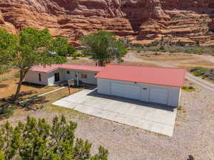 Property featuring a red metal roof, white siding, and an attached two-car garage with white garage doors