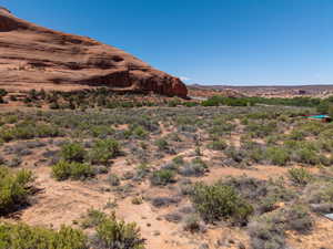 Expansive desert landscape featuring a prominent red rock formation