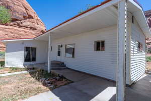 White vinyl siding exterior with an attached covered porch and concrete patio
