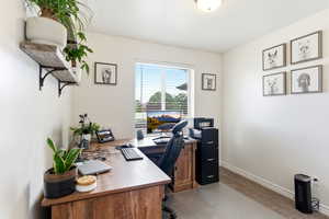Office or bedroom featuring a window with horizontal blinds, neutral-toned carpeting, and light-colored walls