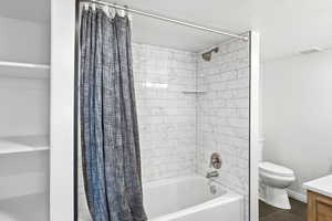 Bathtub with subway tile surround, brushed nickel fixtures, and integrated shelving