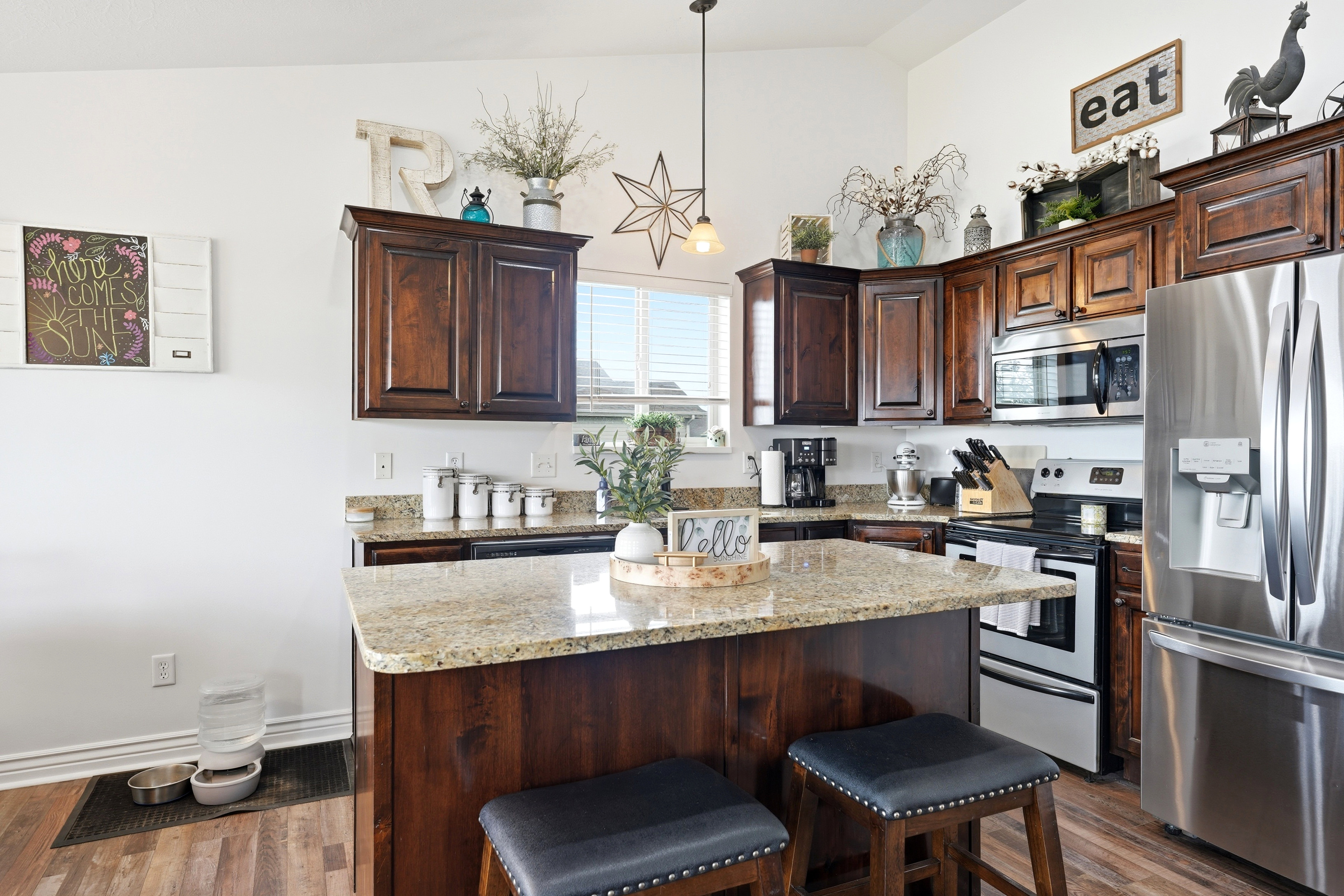 Kitchen island featuring a light-toned granite countertop and dark wood-finish cabinetry