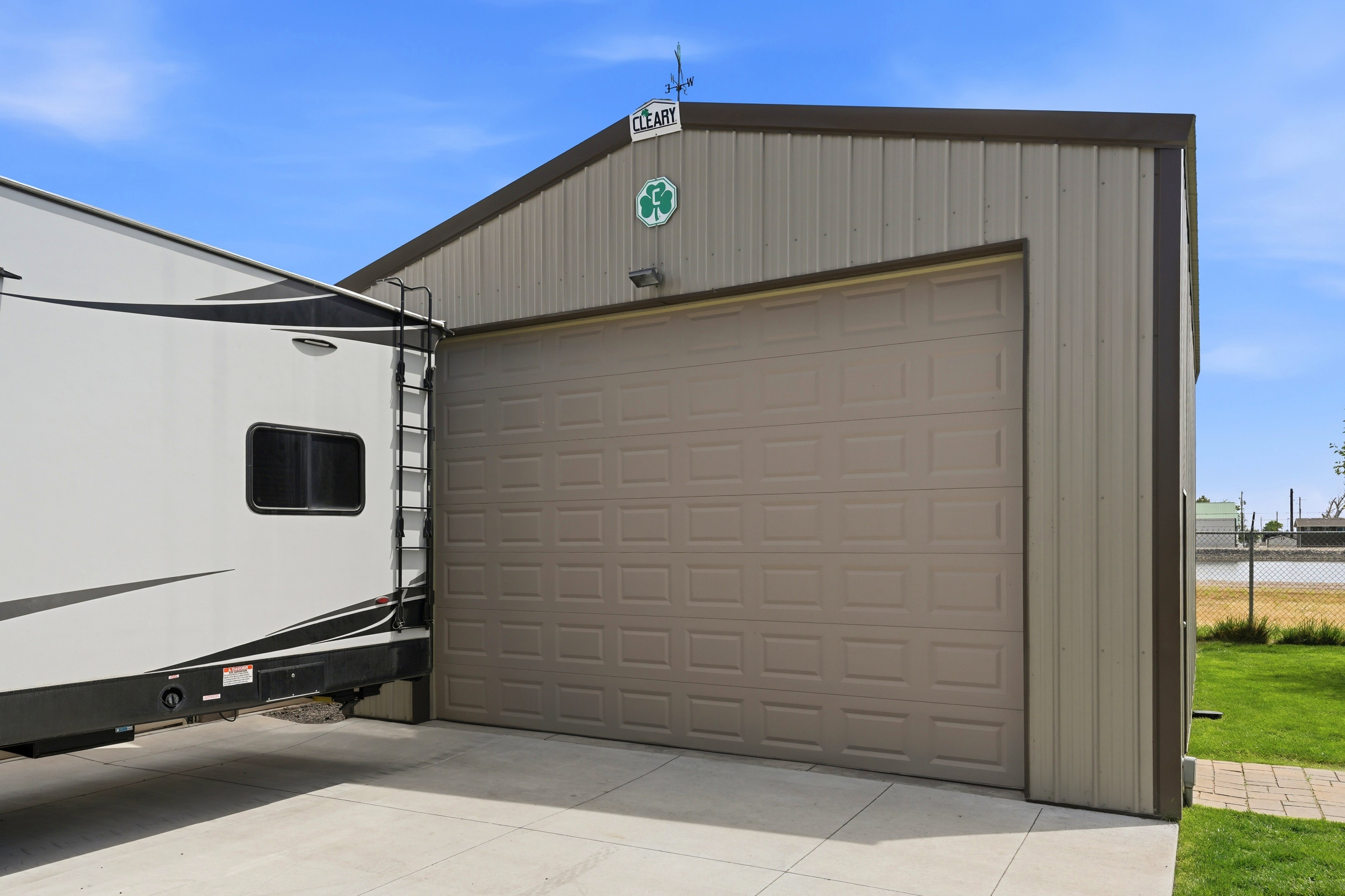 Metal shop 24x32 featuring a paneled garage door, power, 2-220 outlets, and a concrete RV pad in front of it.