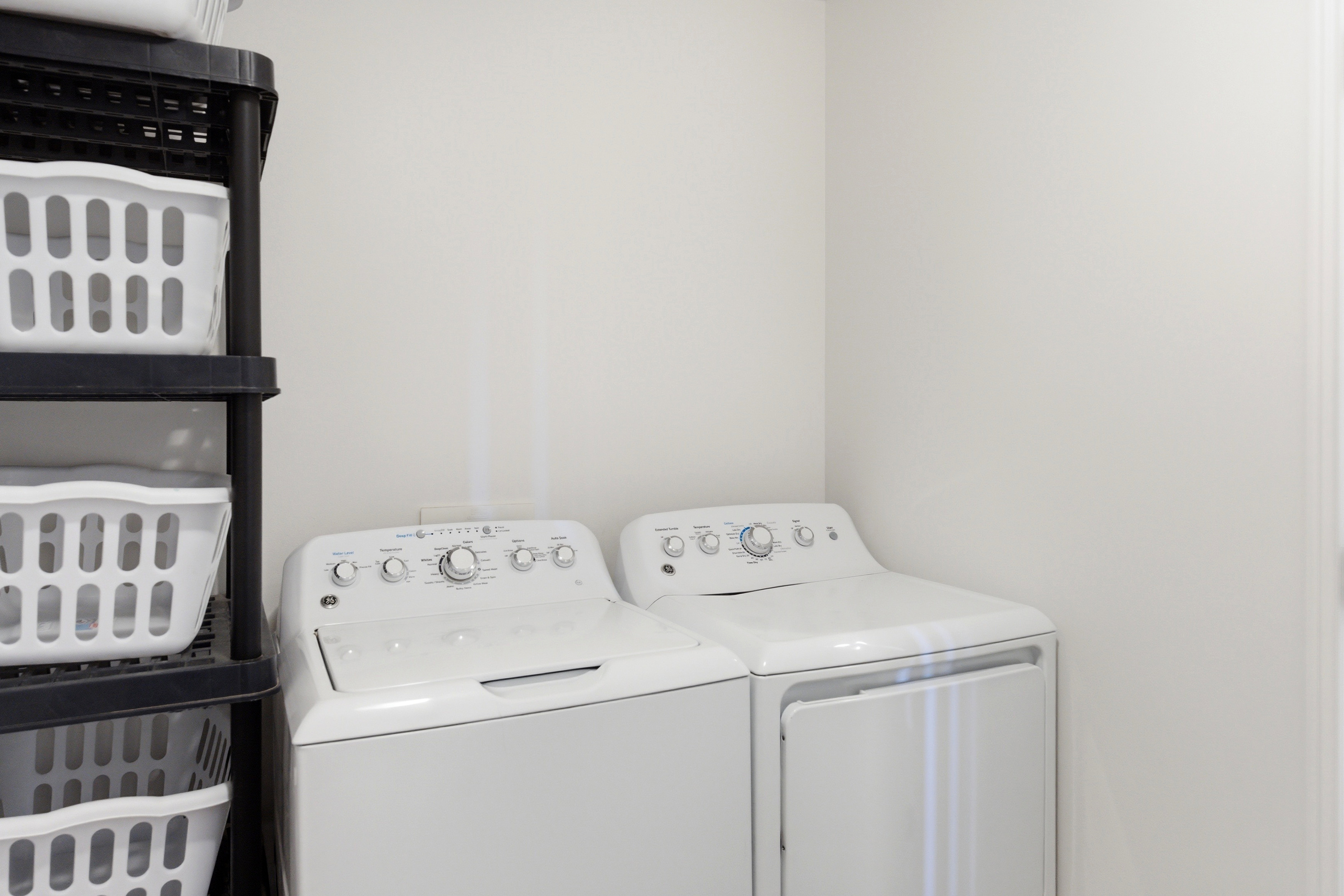 Laundry area featuring white walls and a white top-load washer and dryer set