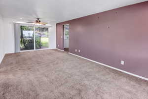 Living area featuring neutral-tone carpeting and a contrasting accent wall