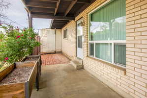 Covered patio area featuring concrete flooring and a wood beam ceiling