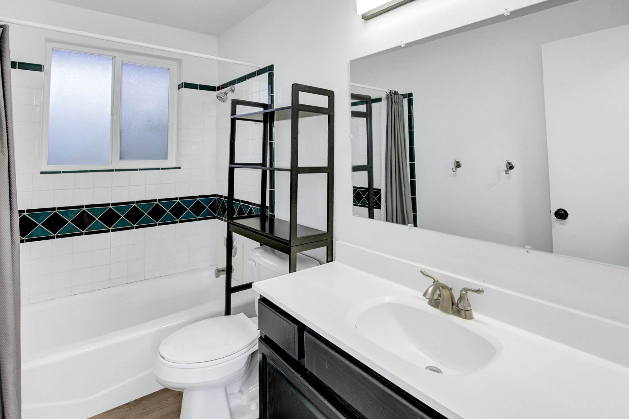 Bathroom featuring a white vanity with an integrated sink, brushed nickel faucet, and a large mirror