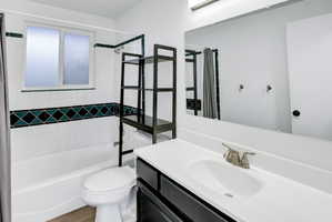 Bathroom featuring a white vanity with an integrated sink, brushed nickel faucet, and a large mirror