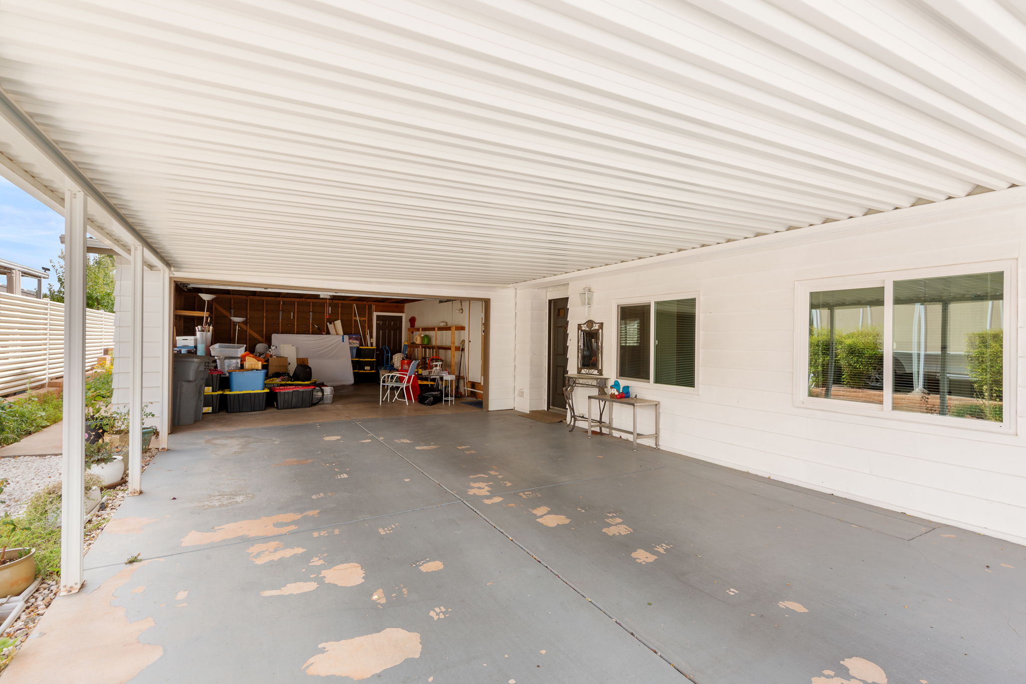 Carport with a corrugated metal roof and painted concrete flooring