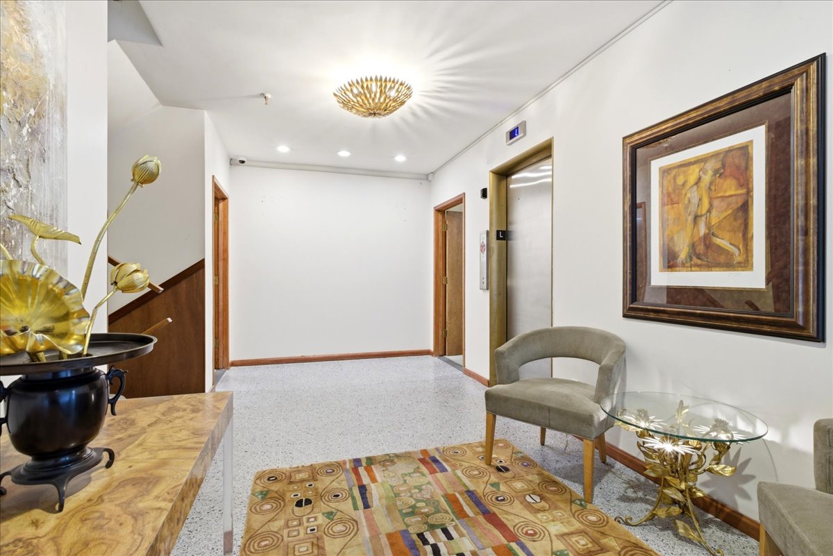 Entry hallway featuring terrazzo flooring, recessed lighting, and a prominent elevator