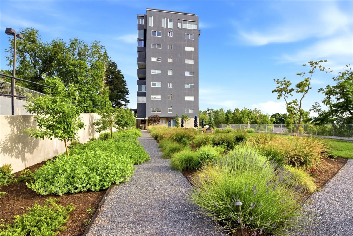 Modern multi-story building featuring a flat gray facade and multiple windows