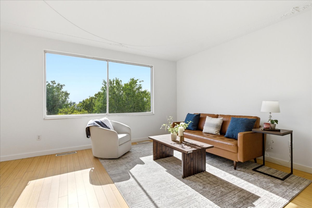 Spacious room featuring light wood-finish flooring and expansive windows