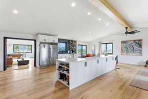 Expansive kitchen featuring a large central island with white cabinetry and a light-toned countertop