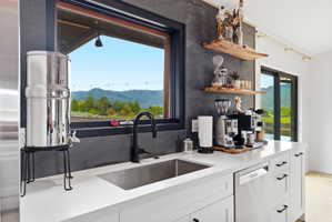 Kitchen area featuring white cabinetry, a stainless steel undermount sink with a matte black faucet, and a stainless steel dishwasher
