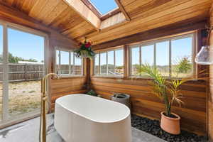 Freestanding soaking tub with a floor-mounted golden-finish faucet
