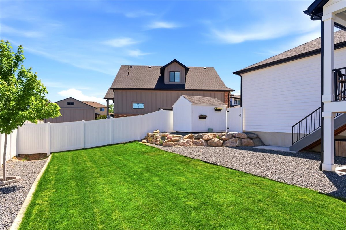 Expansive backyard featuring a lush lawn and  white vinyl fencing