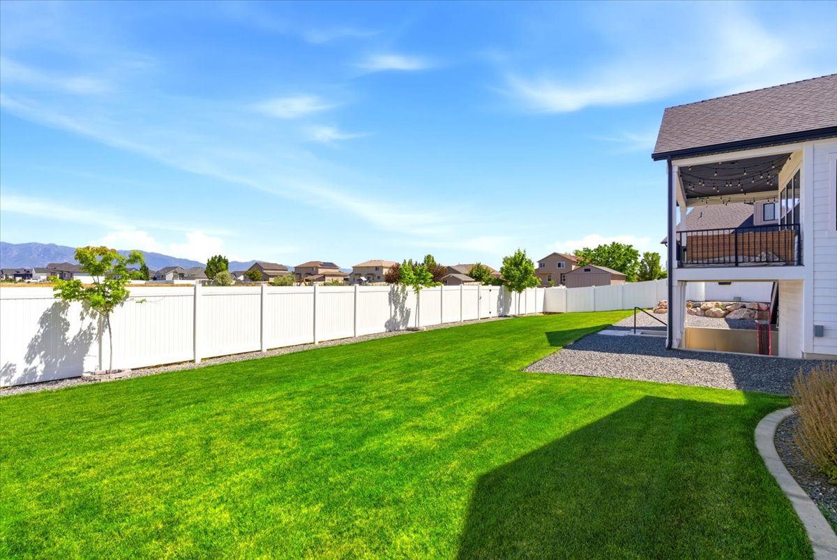 Expansive green lawn framed by a white privacy fence