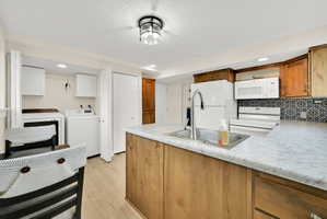 Kitchen featuring wood-finish cabinetry, patterned tile backsplash, and light-toned countertops