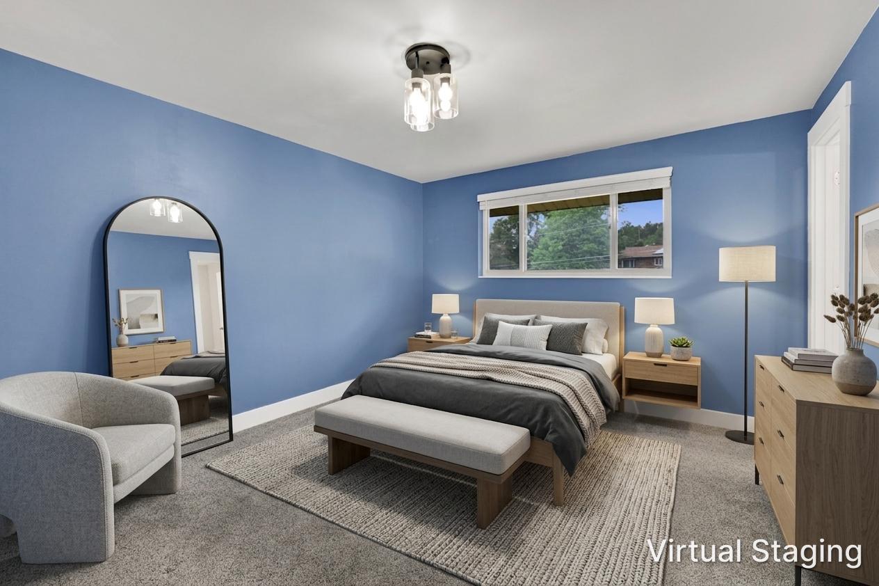 Carpeted room with a multi-paned window, white trim, and a semi-flush mount ceiling light fixture. Room was virtually staged.