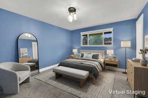 Carpeted room with a multi-paned window, white trim, and a semi-flush mount ceiling light fixture. Room was virtually staged.