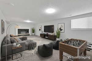 Spacious recreational area featuring a fireplace with a dark brick facade and a wide hearth. Room was virtually staged.