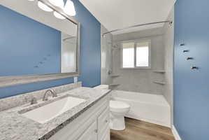 Bathroom featuring a white vanity with a granite-style countertop and an undermount sink