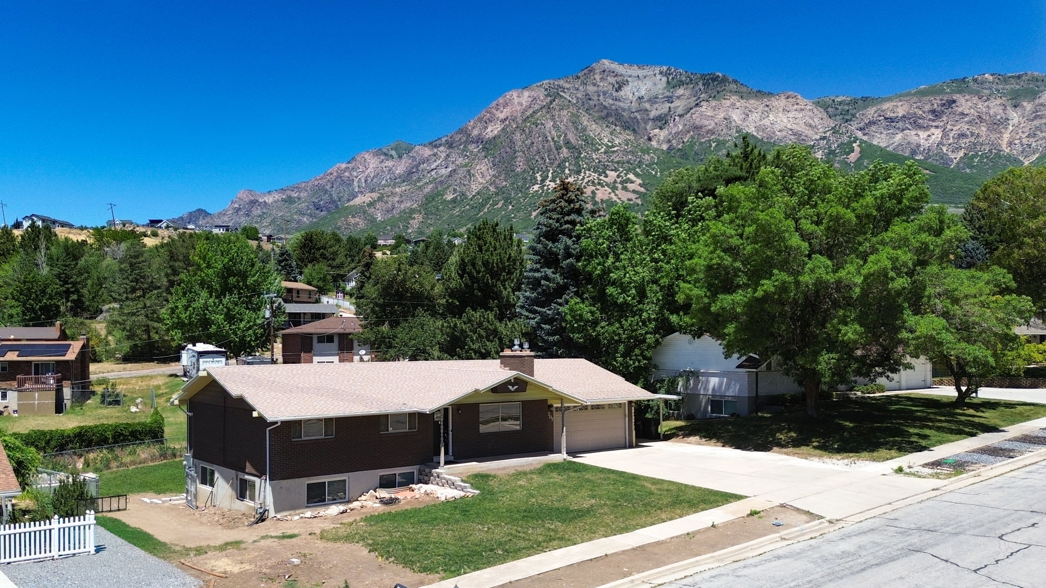 Ranch-style residence featuring a brown facade, attached garage, and a light-toned roof