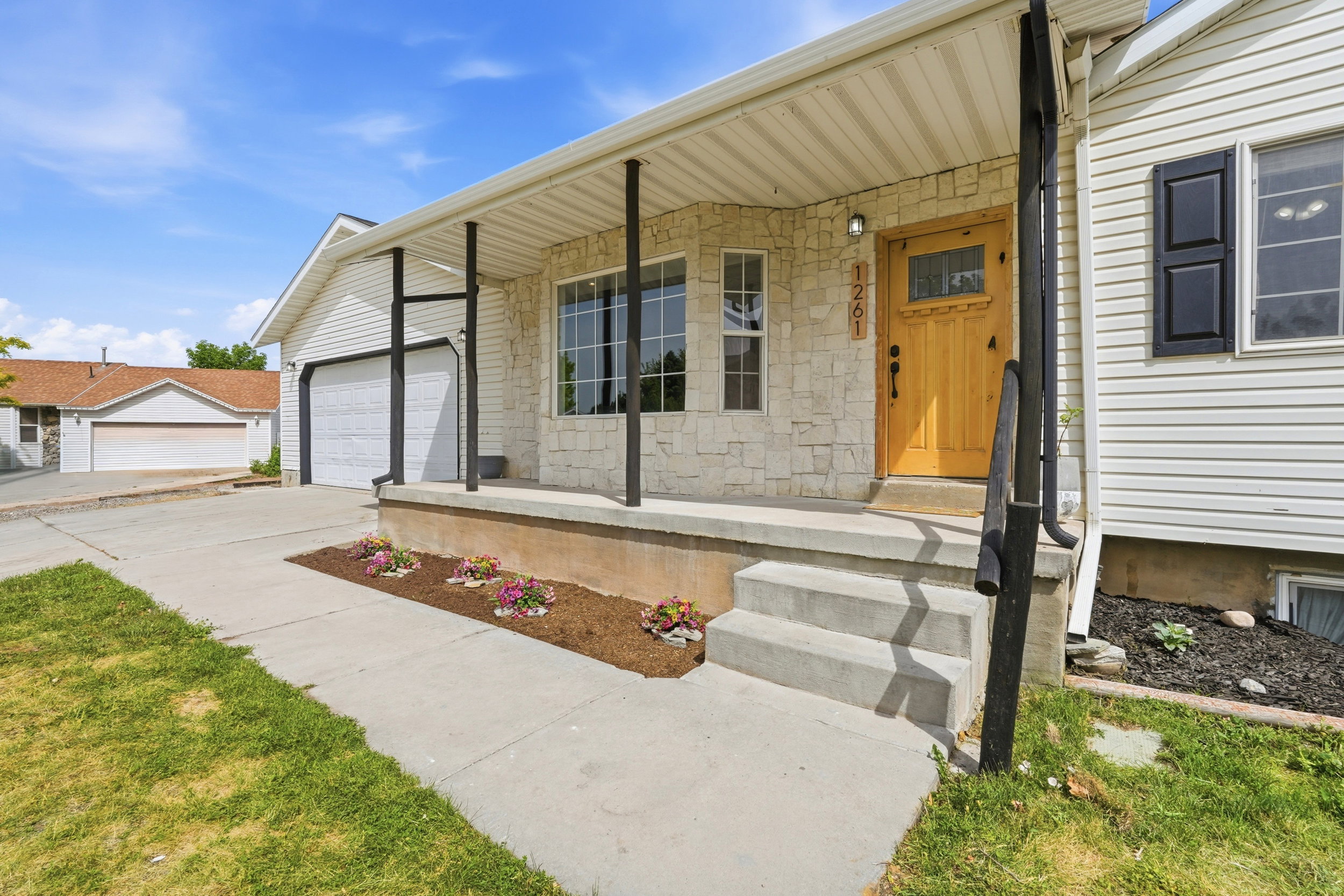 Home exterior featuring white siding and a stone facade around the entryway