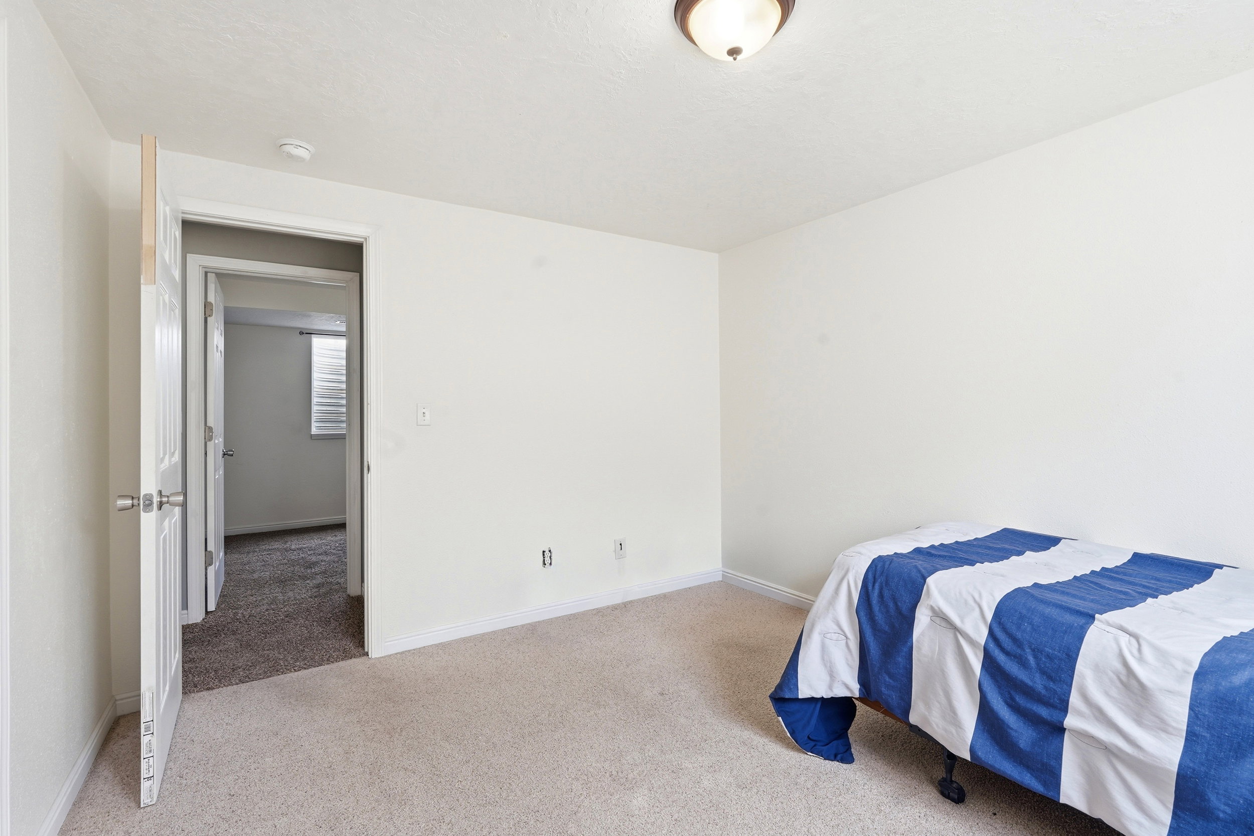 Interior room with white walls, white trim, and a white paneled door