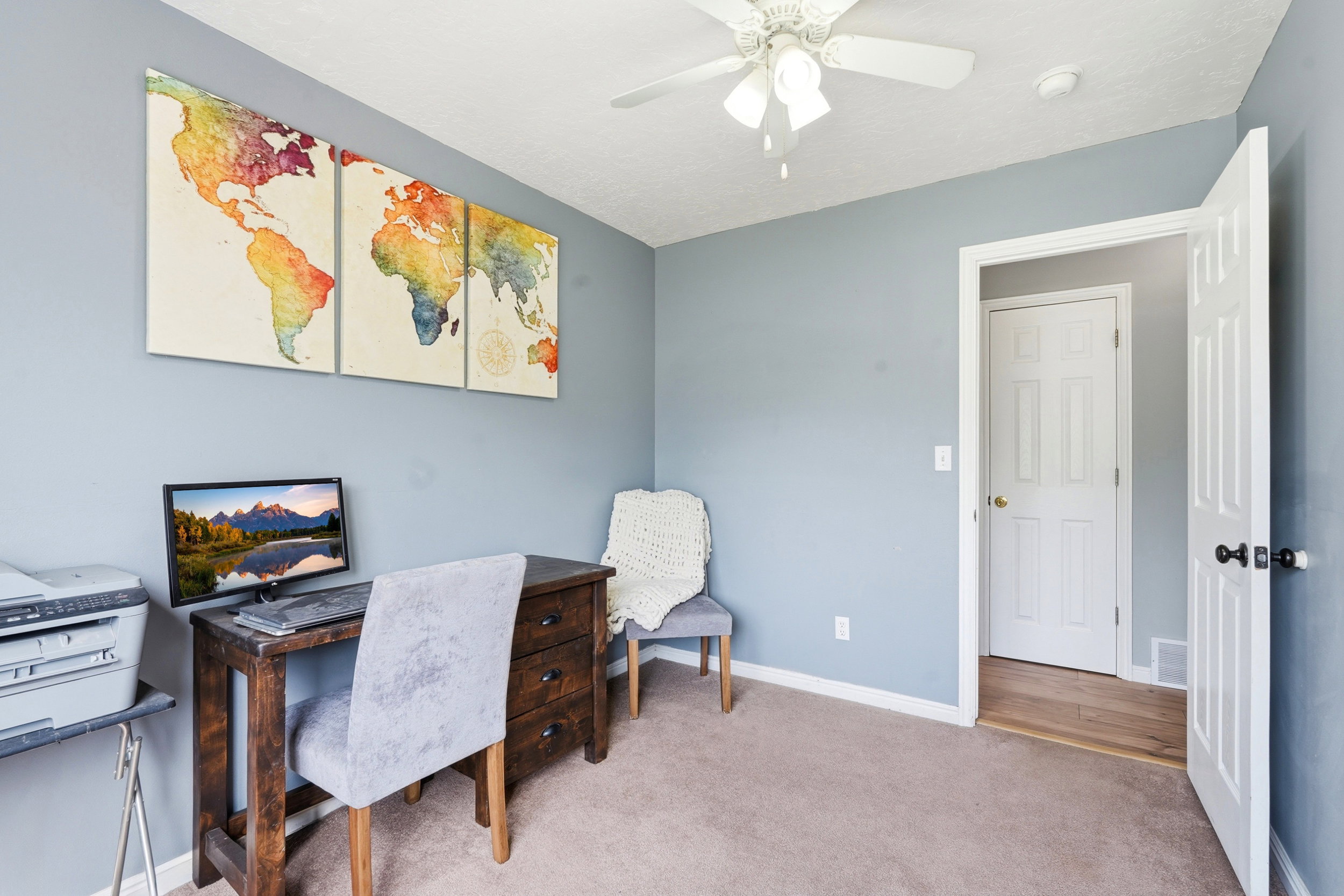 Carpeted room featuring light blue painted walls, a white ceiling fan with integrated lighting, and white trim